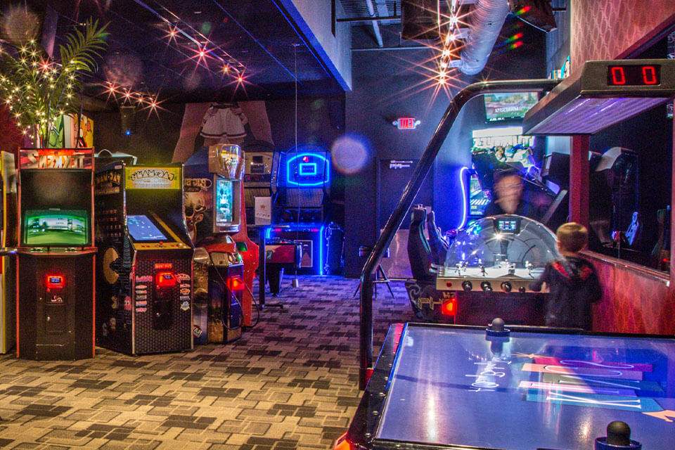 A video arcade with several games and an air hockey table