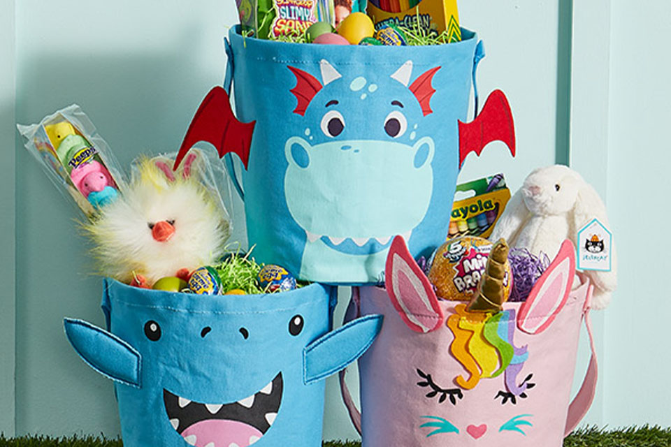 Three baskets with cartoon characters on them. They are filled with candy, as well as arts and crafts supplies